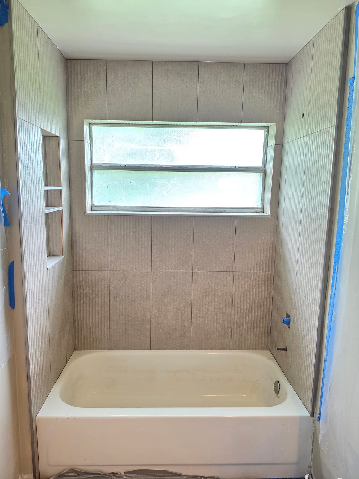 Rectified porcelain over tub walls with niche and window sill